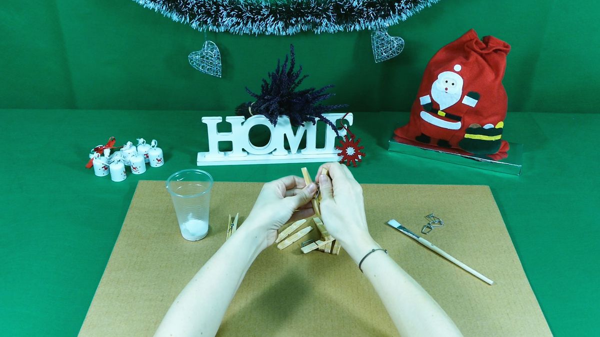 Paso uno para hacer estrellas de Navidad con pinzas de madera.