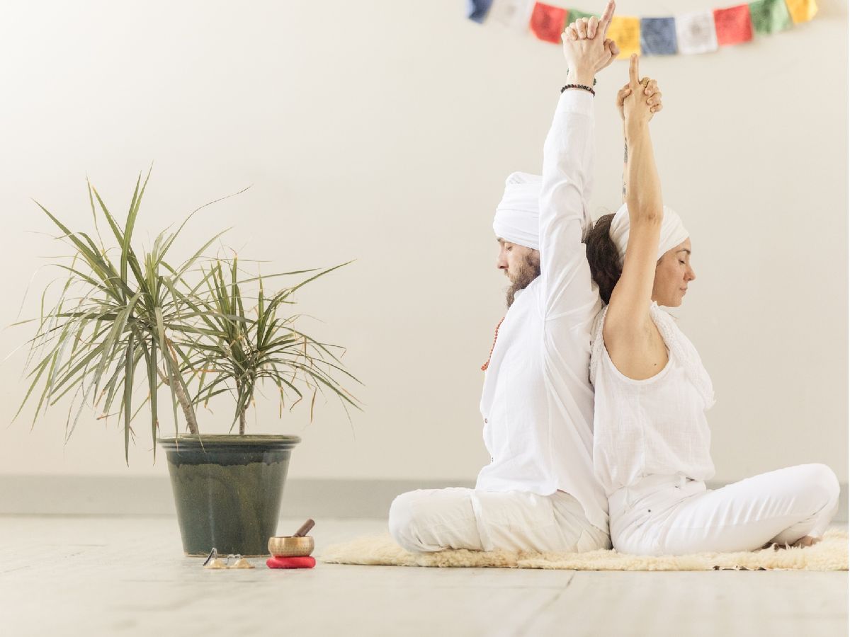 Postura de yoga de un estiramiento de espalda en pareja