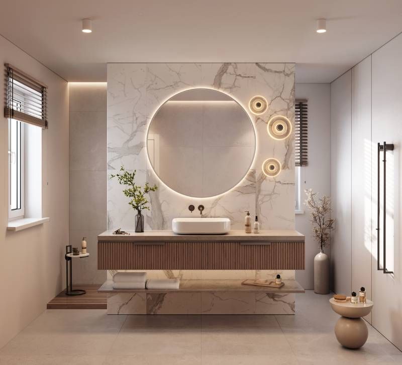 Baño de estilo minimalista con encimera de mármol, espejo redondo y una planta.