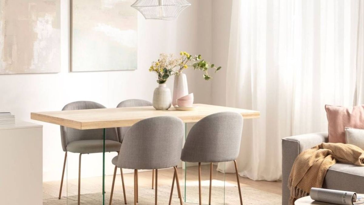 Salón comedor con mesa rectangular de madera clara y sillas grises.