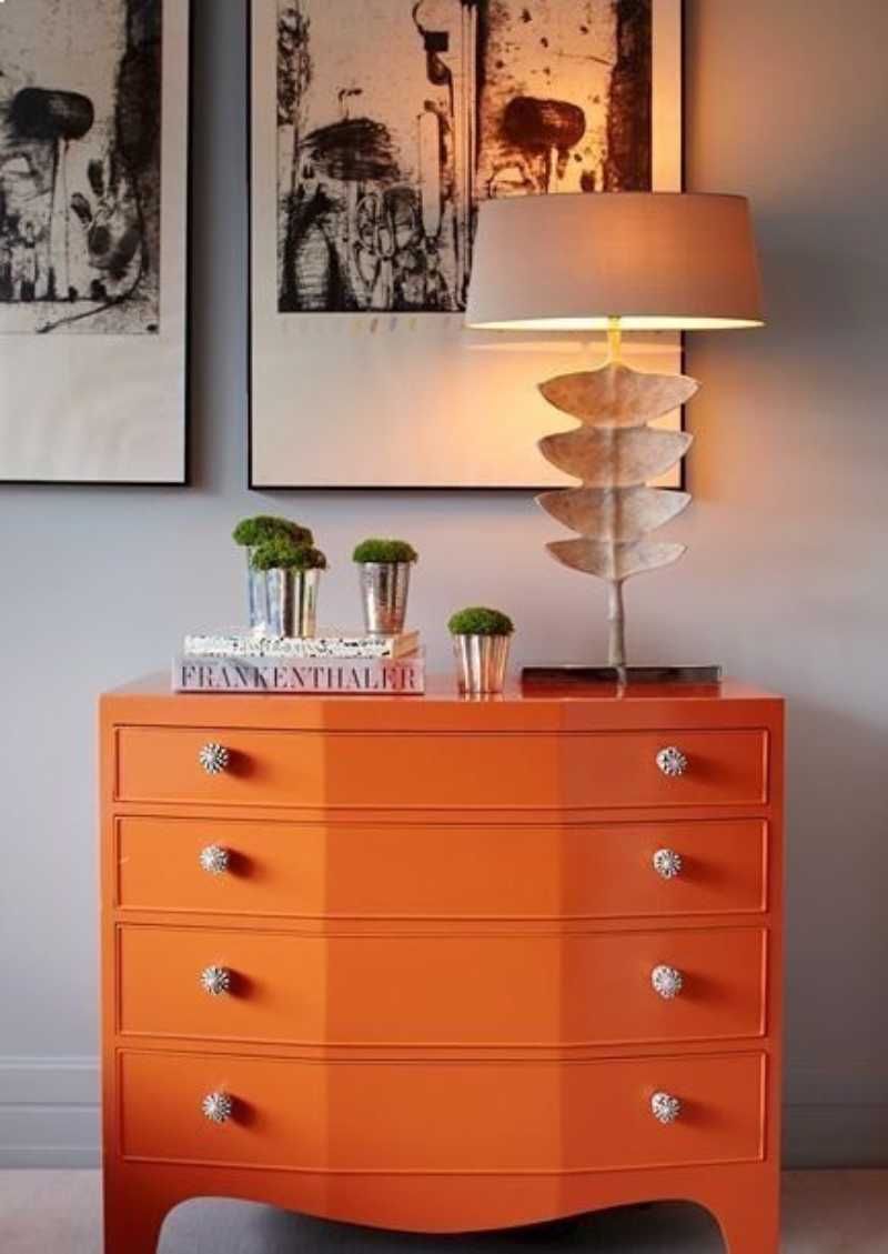 Cómoda naranja pintada con pintura a la tiza.