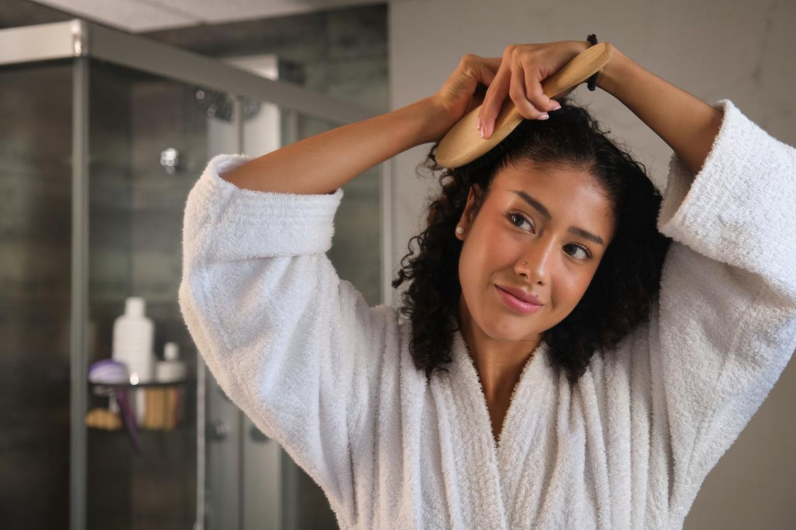 Mujer cepillándose el pelo limpio.