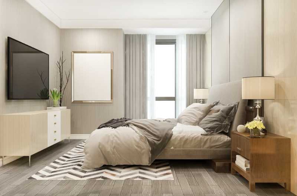 Dormitorio pequeño con alfombra a los pies de la cama.