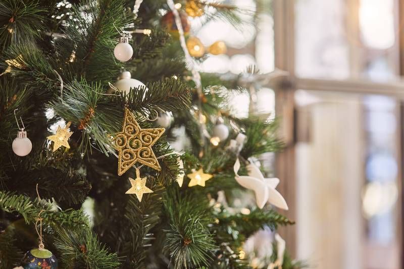 Árbol de Navidad con adornos dorados y plateados.