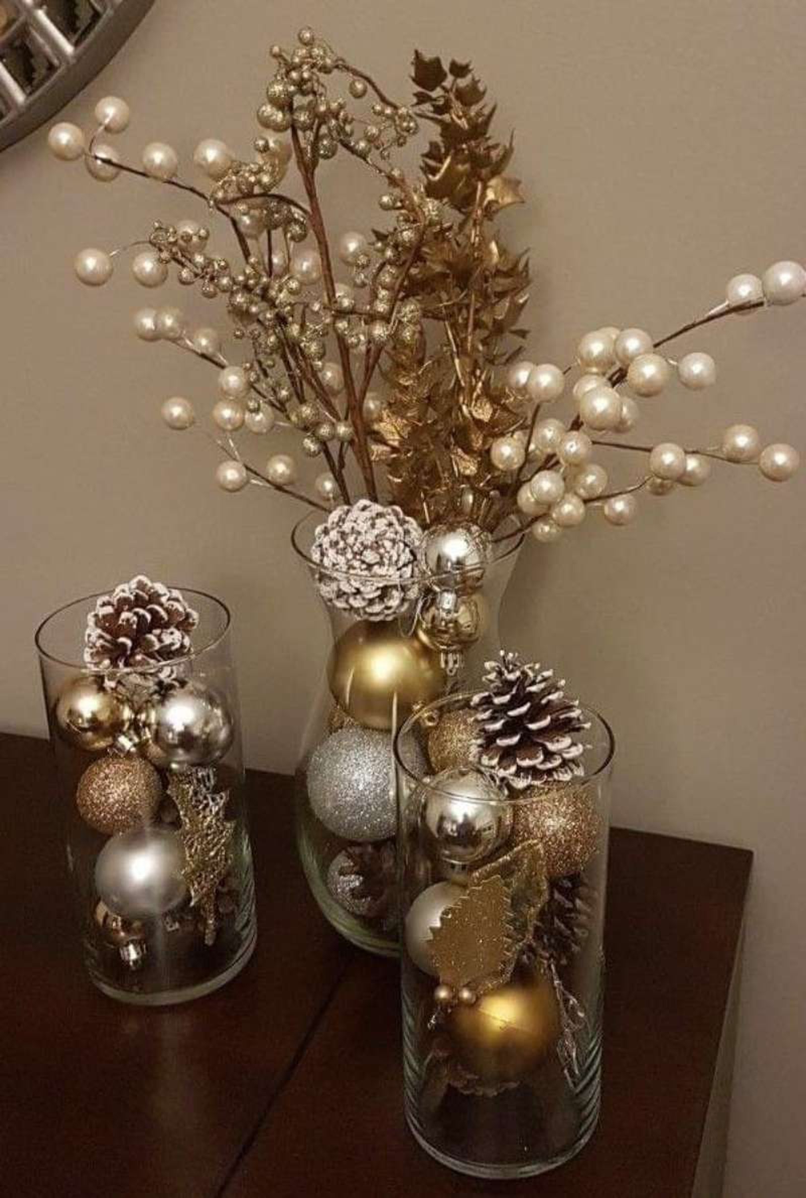 Jarrones de Navidad decorados con piñas secas y bolas.