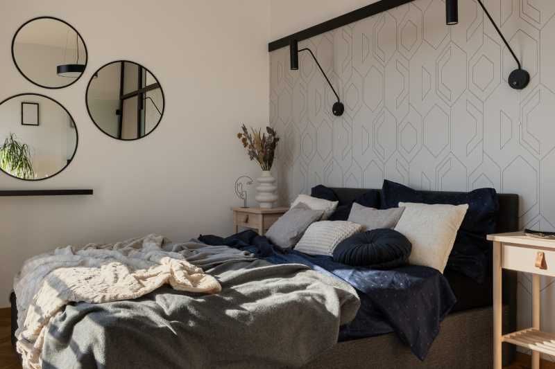 Dormitorio con papel pintado geométrico.