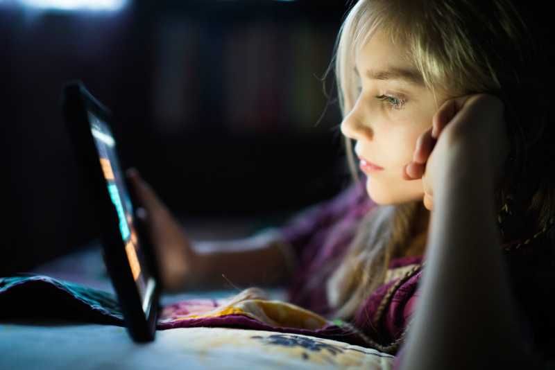 Niña mirando la pantalla de la tablet.
