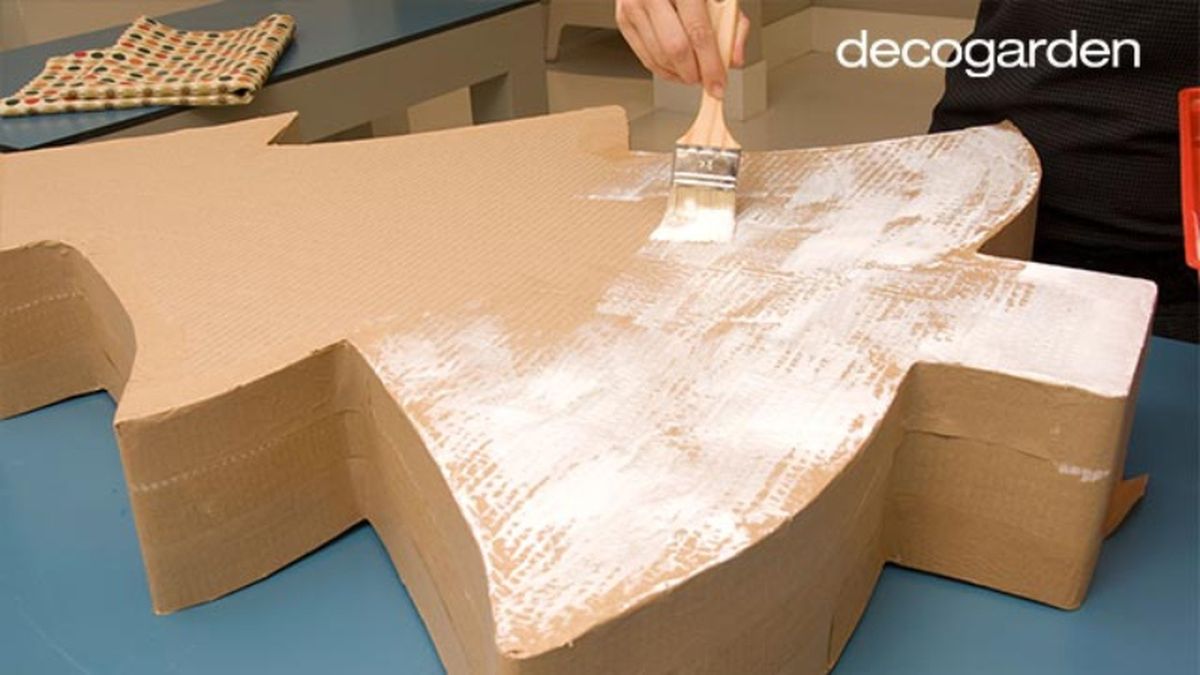 Aplicar adhesivo al árbol de Navidad de cartón para pegar la tela.