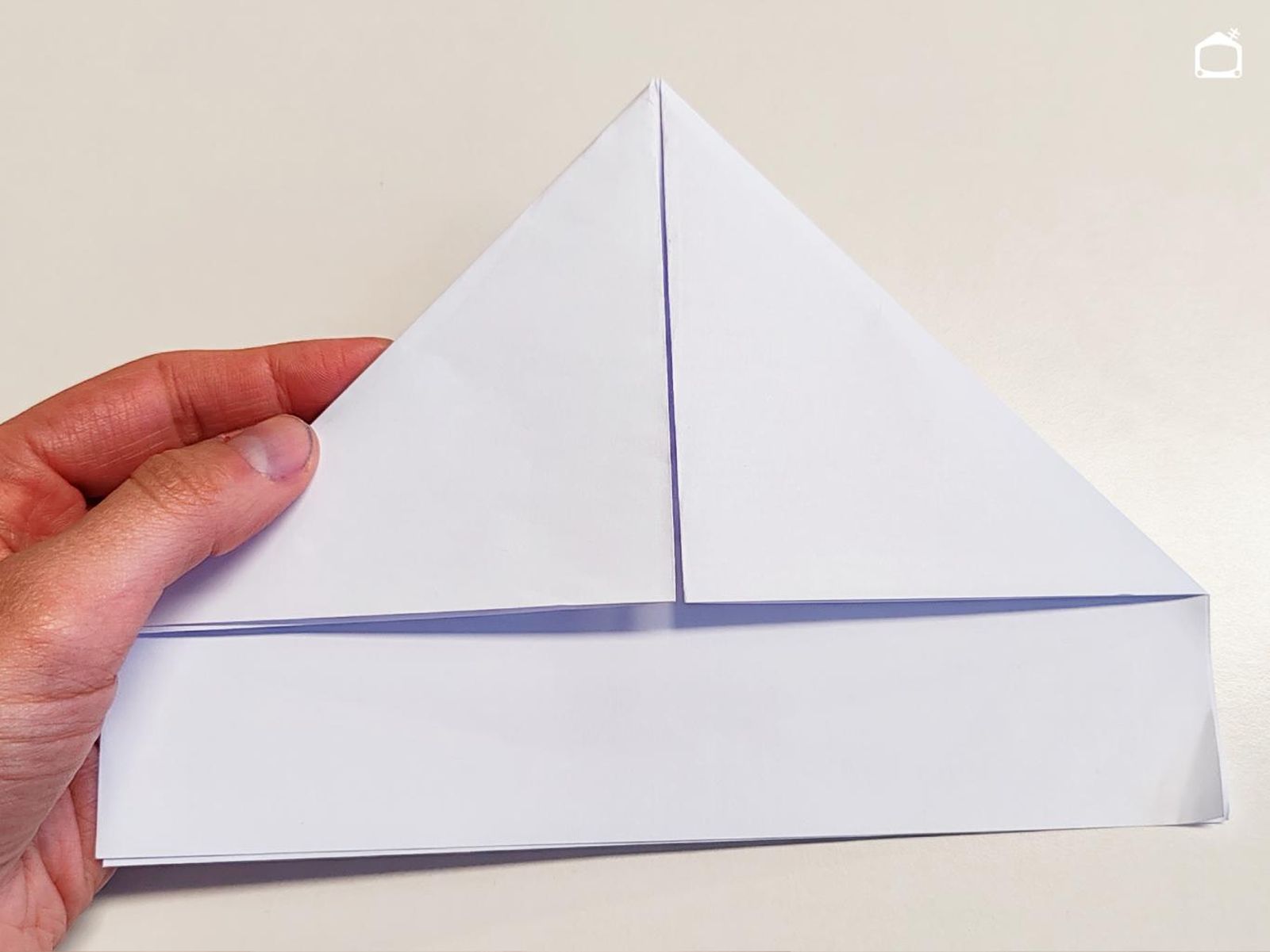 Segundo paso para hacer un barco de papel.
