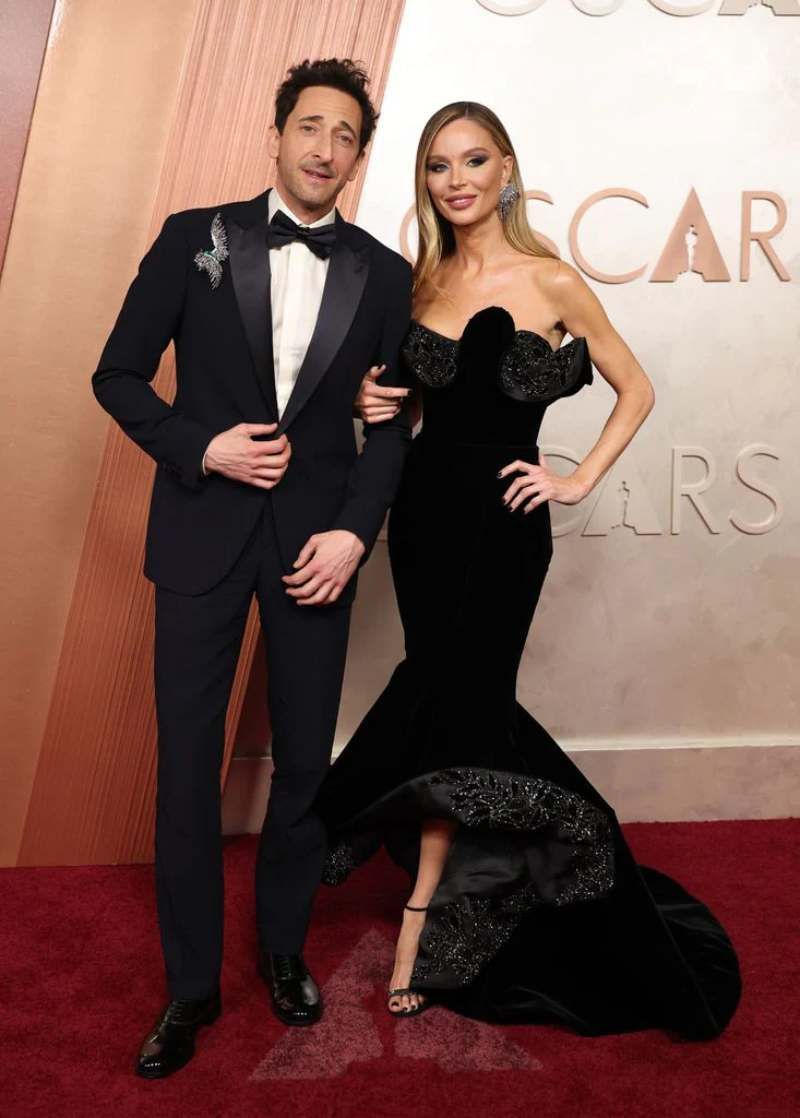 Georgina Chapman con Adrien Brody en la alfombra roja de los Premios Oscar 2025
