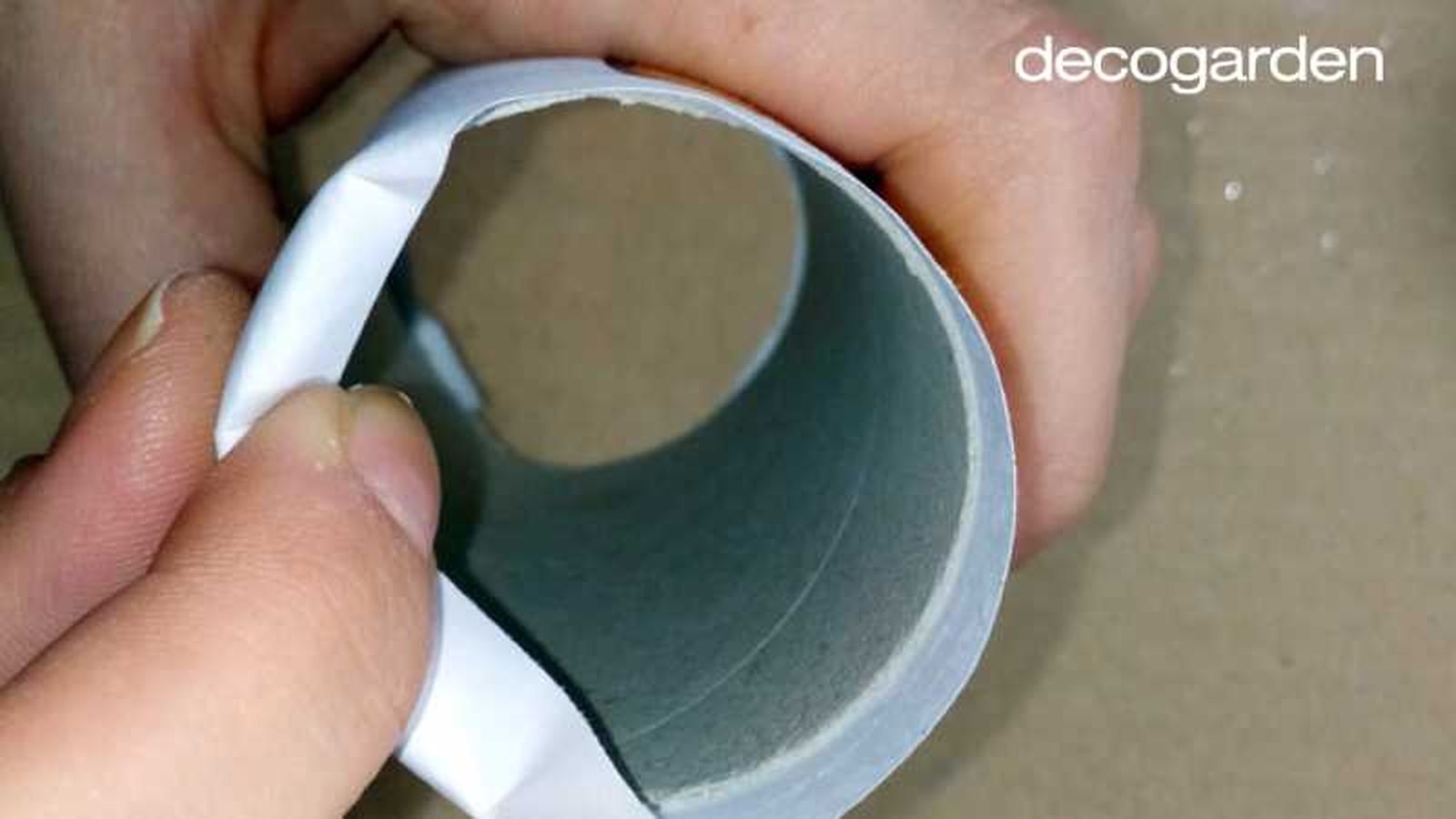 Meter los extremos de las ilustraciones dentro del rollo de papel higiénico.