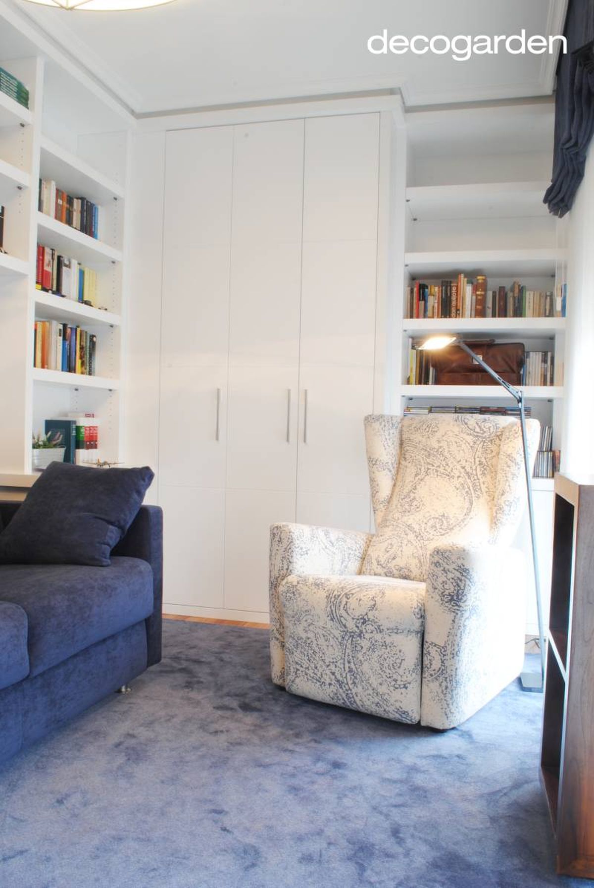 Estudio decorado en tonos azules con rincón de lectura.