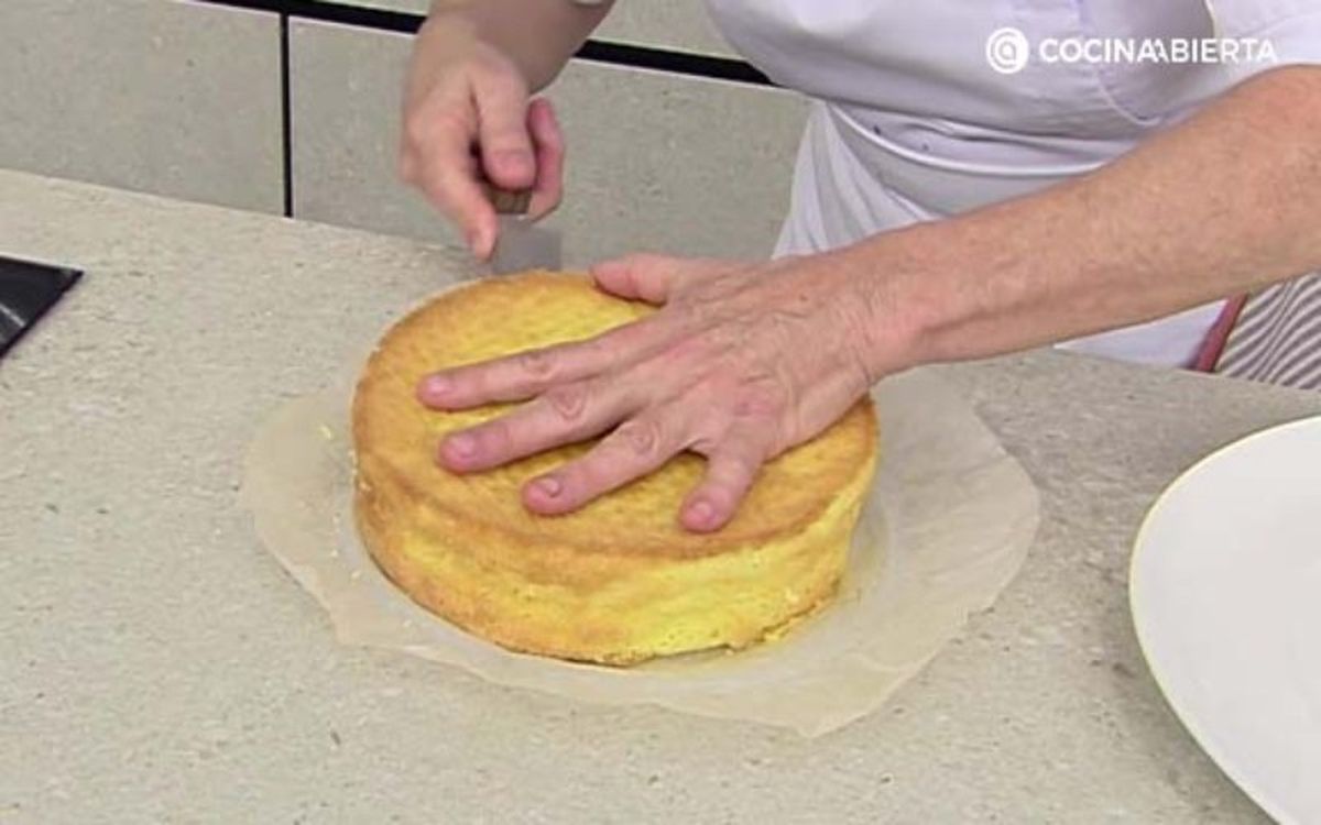 Corta el bizcocho por la mitad de manera uniforme con un cuchillo de sierra largo