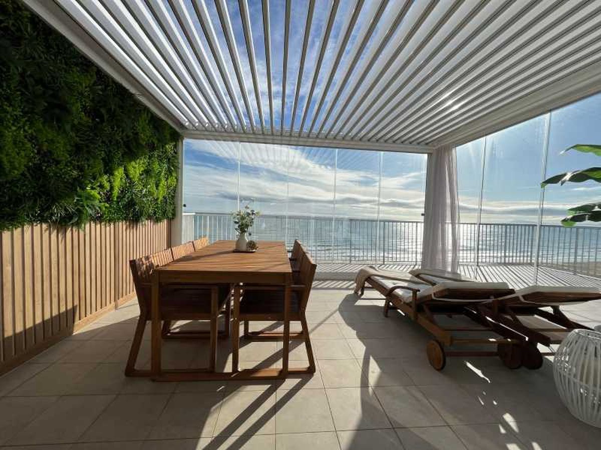 Terraza con pérgola bioclimática con jardín vertical.