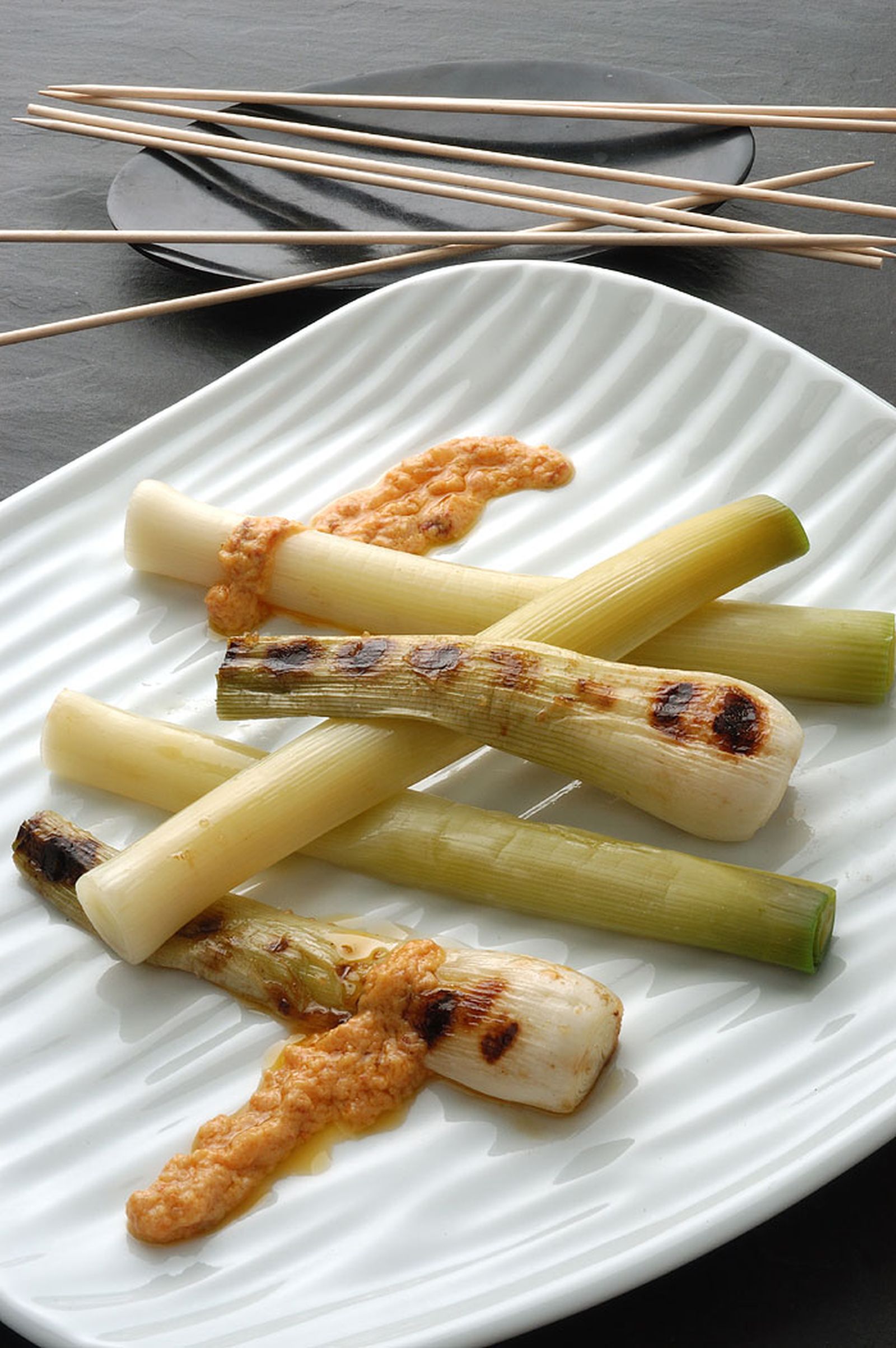 Puerros y cebolletas con salsa romesco