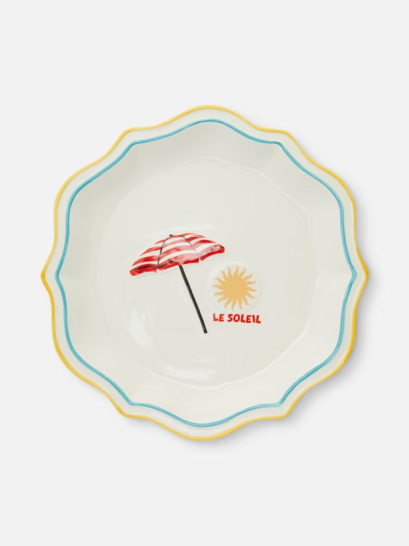 Plato con estampado de sombrilla y sol y borde festonado.