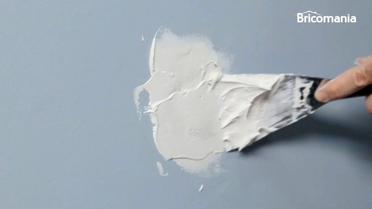 Persona tapando un agujero de la pared