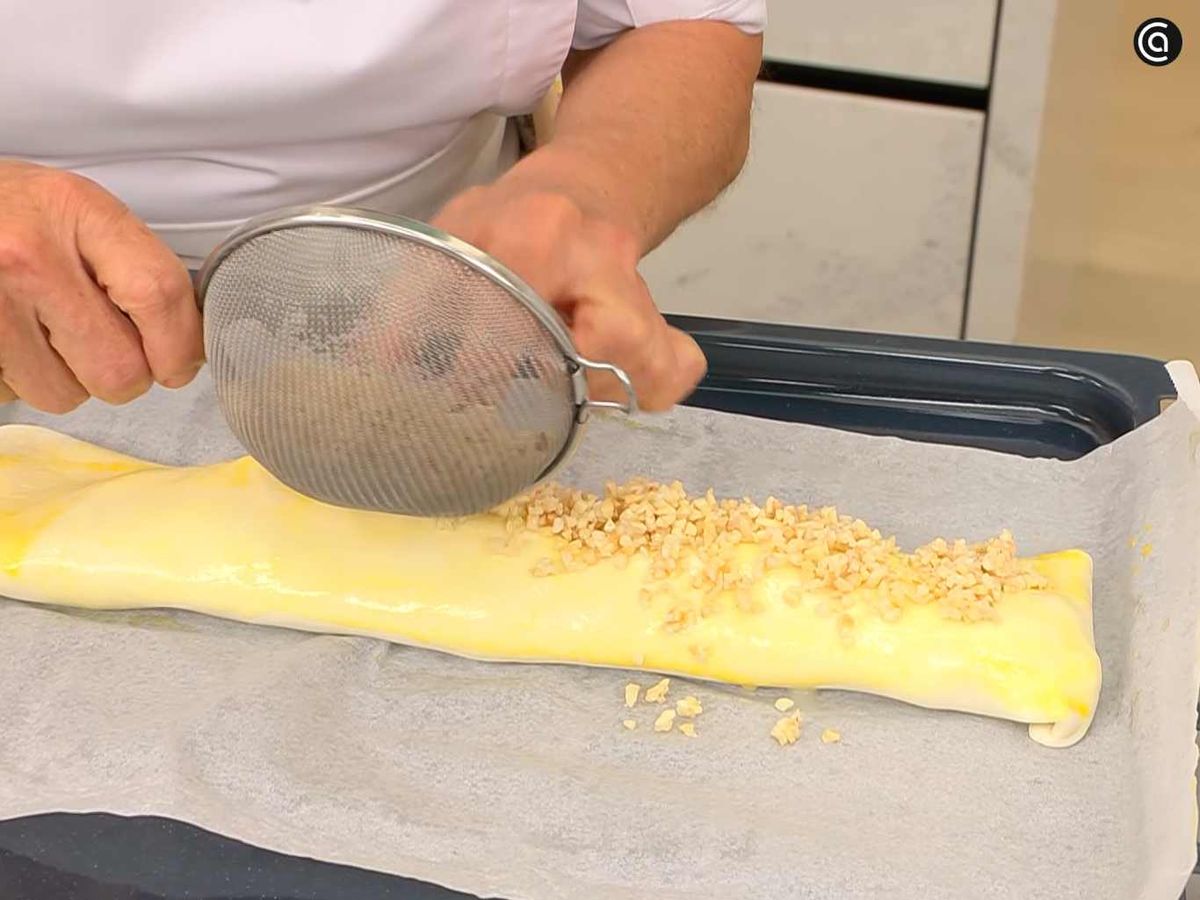 Enrolla el hojaldre y cubre de almendras