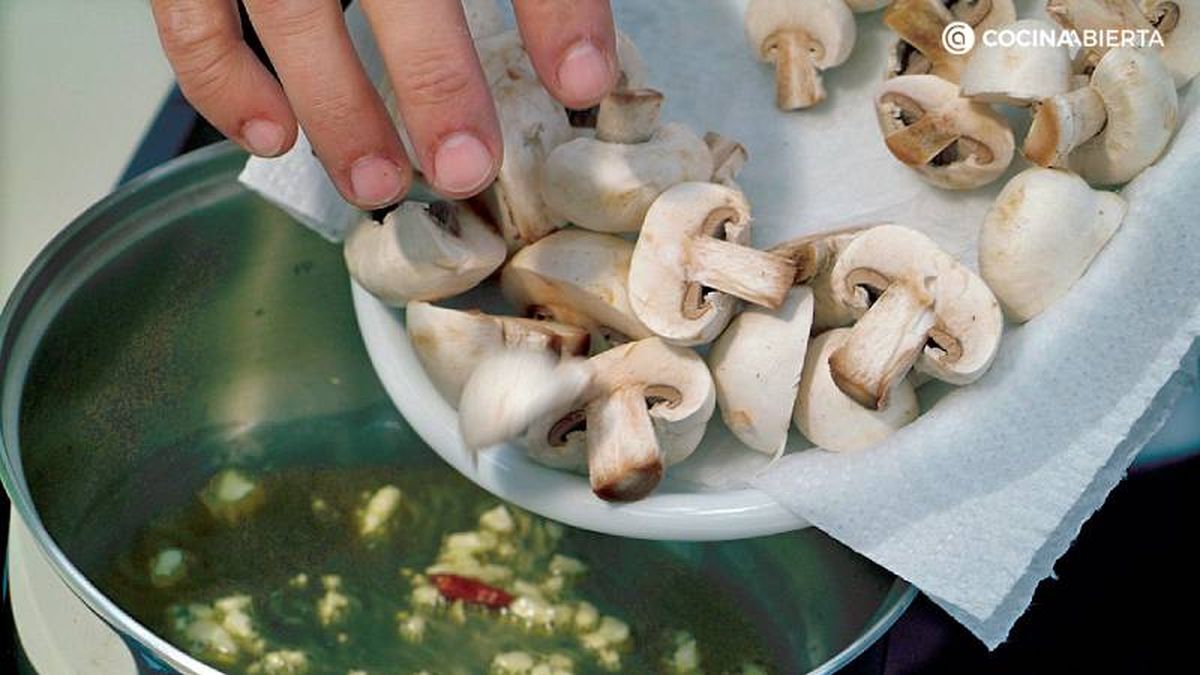 Añade los champiñones a sofrito de ajo y guindilla