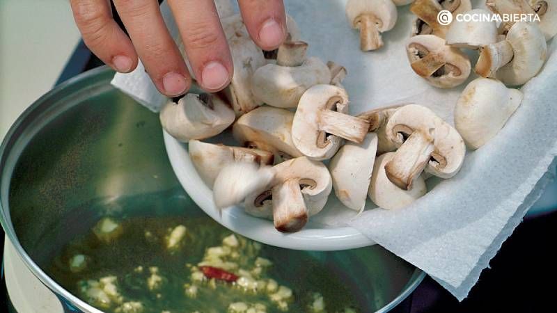 Añade los champiñones a sofrito de ajo y guindilla
