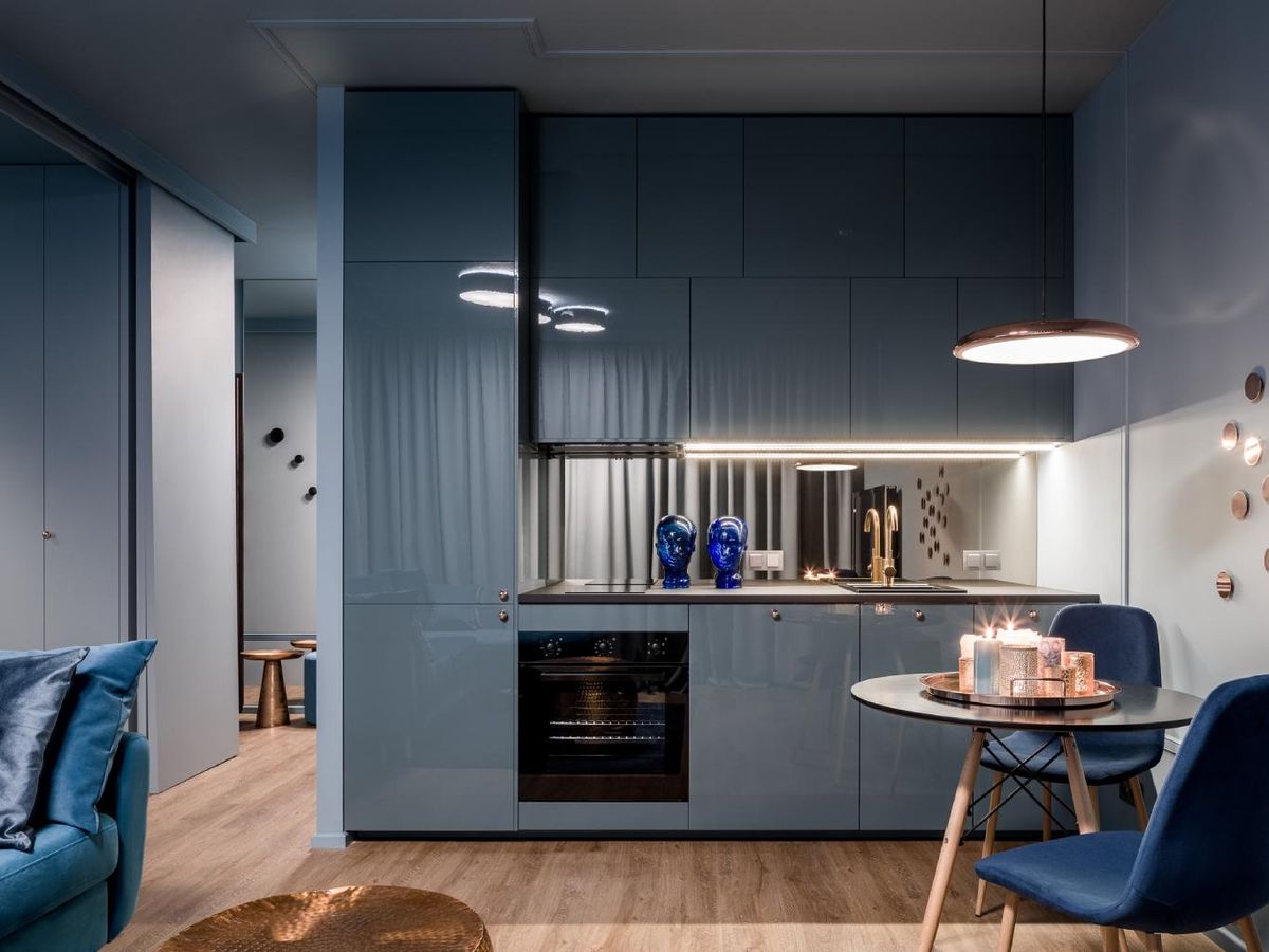 Cocina azul moderna con iluminación artificial.