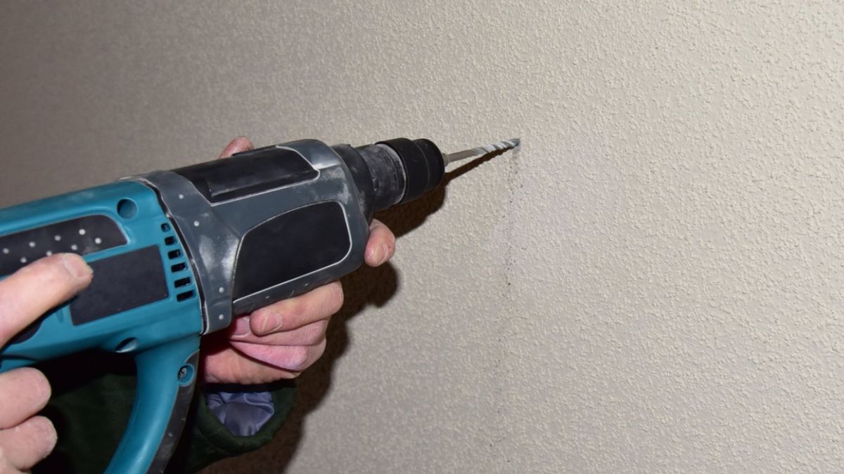 Persona taladra una pared
