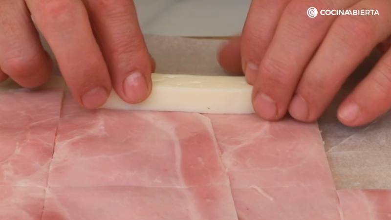 Coloca una tira de queso en el extremo de cada rectángulo y enrolla