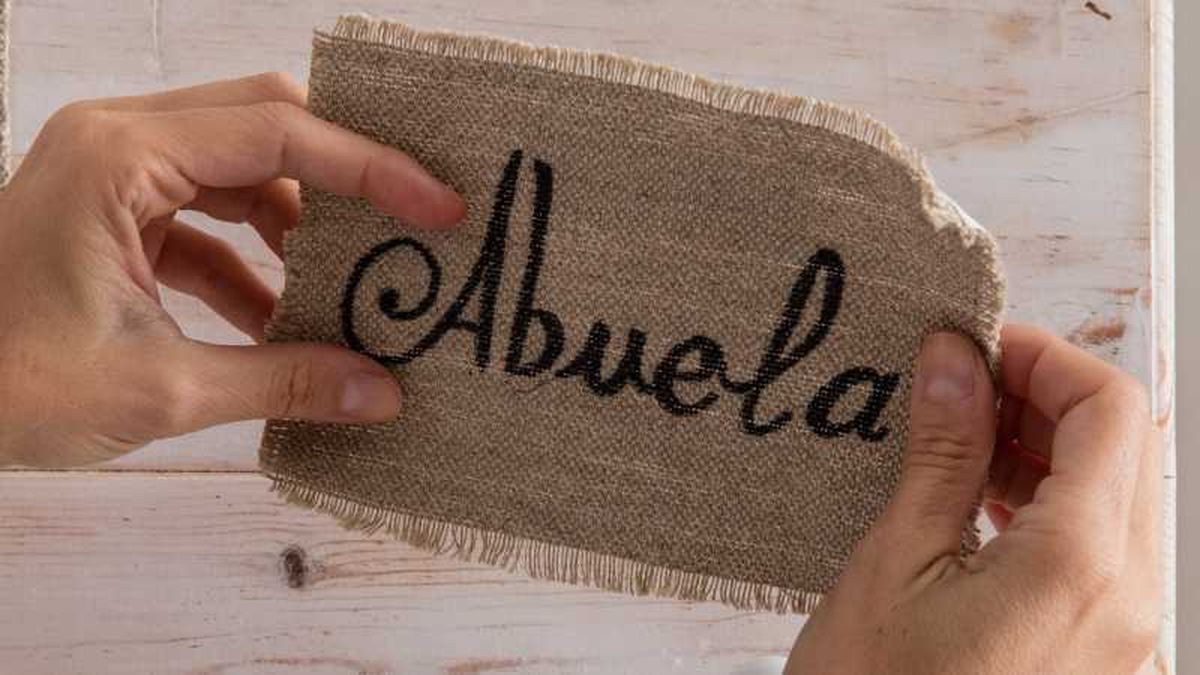 Abuela escrito sobre tela de saco para hacer el perchero navideño.