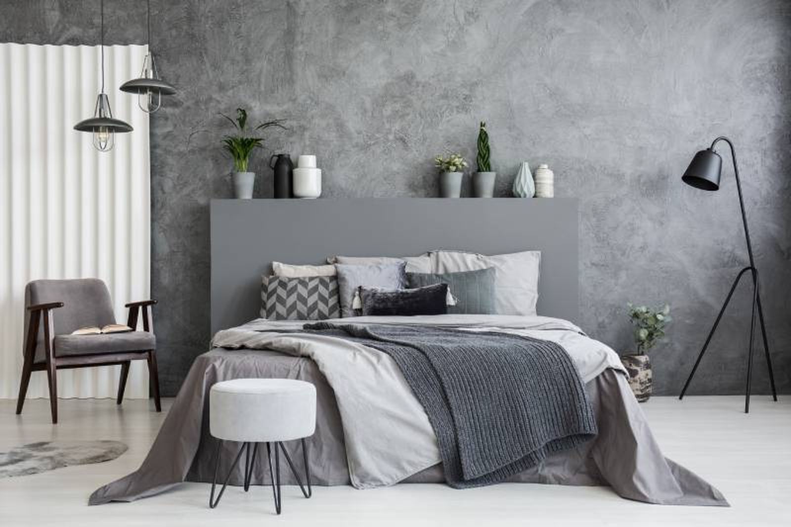 Dormitorio sencillo con cabecero de cama gris liso.