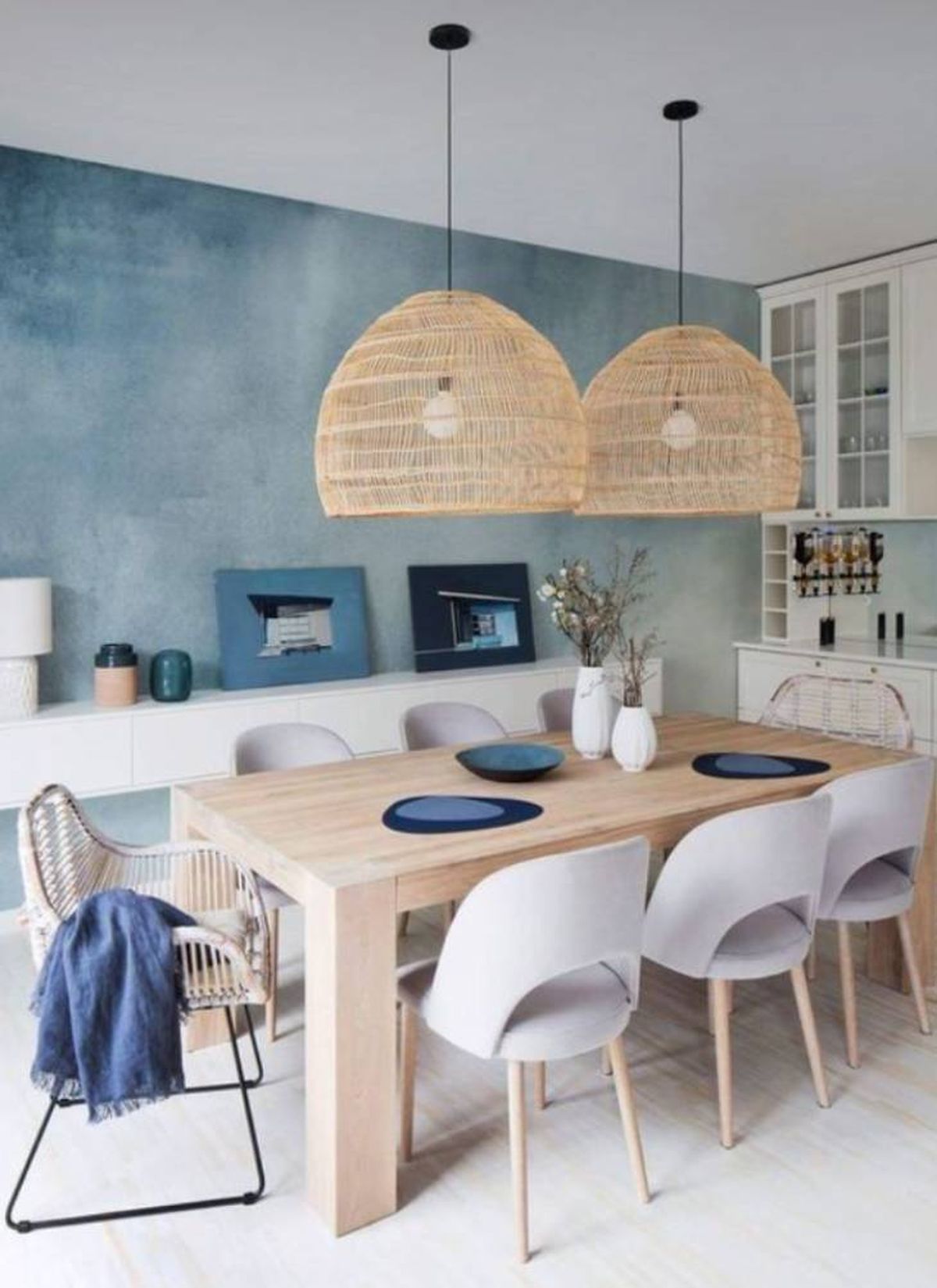 Cocina de estilo mediterráneo con pared azul y lámparas de fibras naturales.