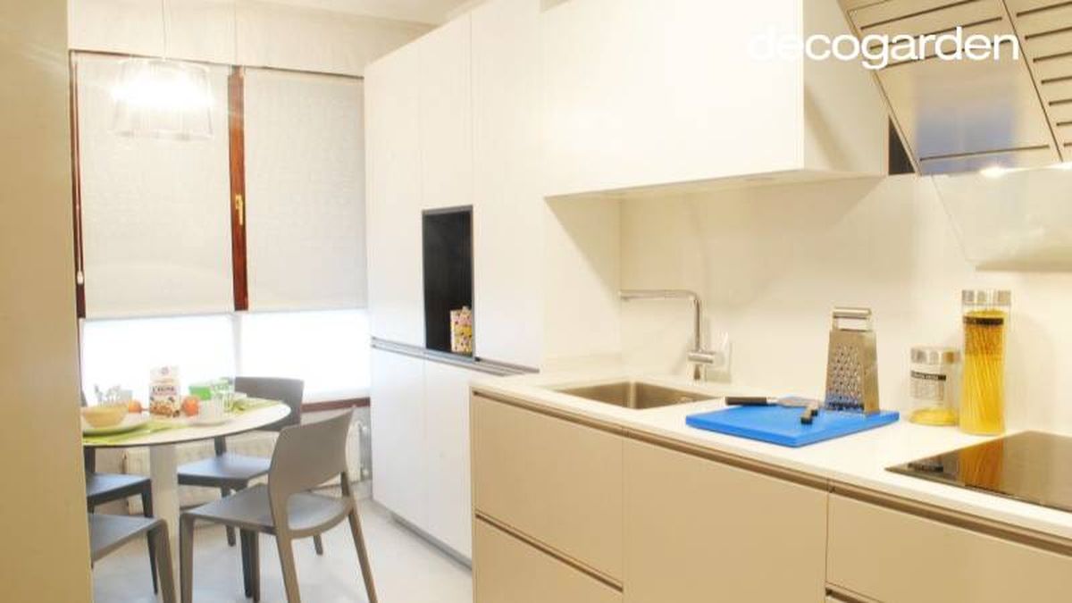 Cocina en blanco y visón con zona de desayuno.