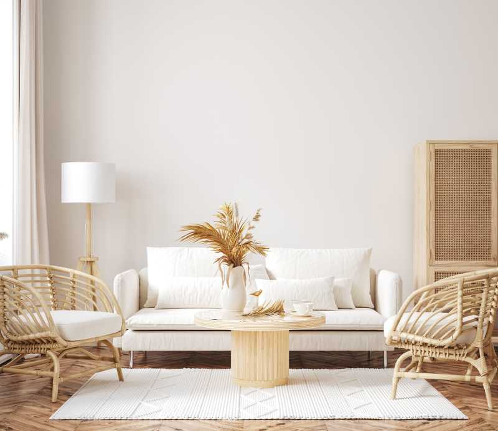 Salón bohemio blanco con muebles de ratán.