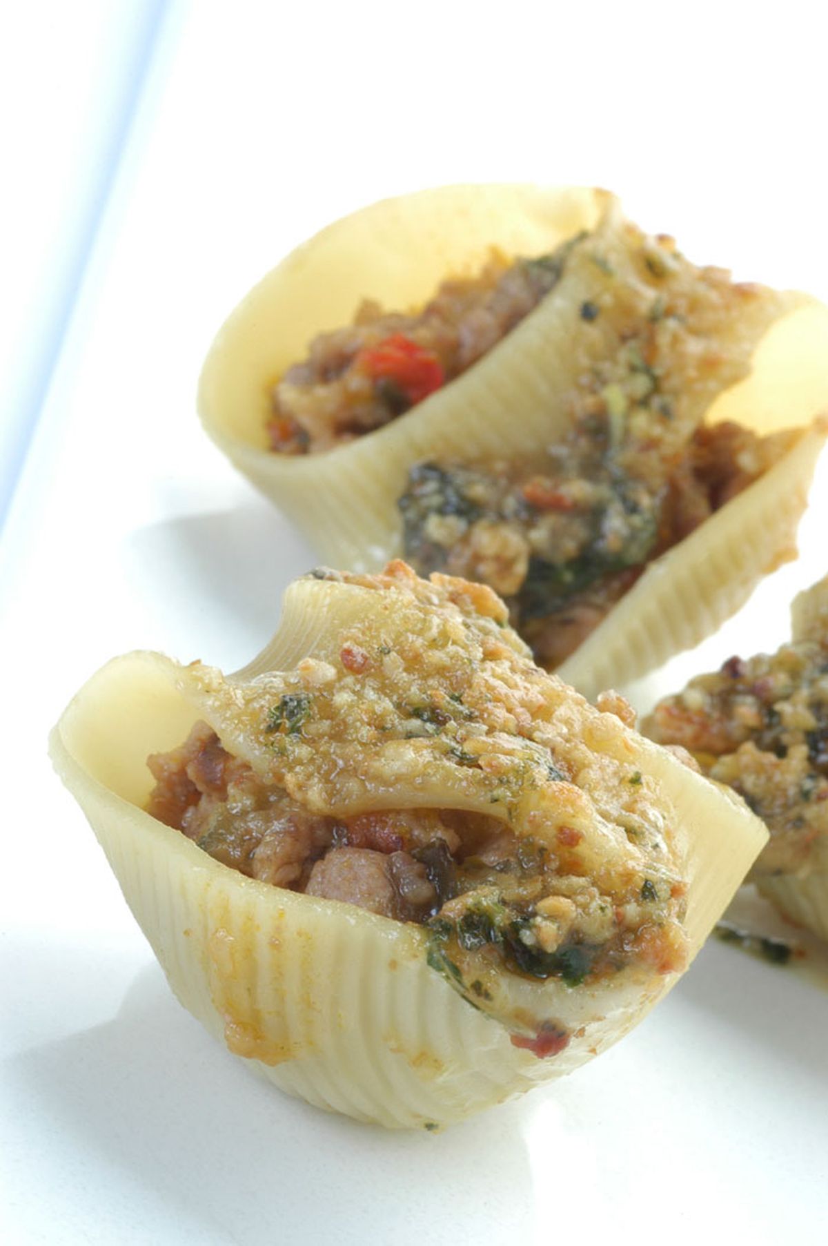 Pasta rellena de carne con salsa de piñones y albahaca