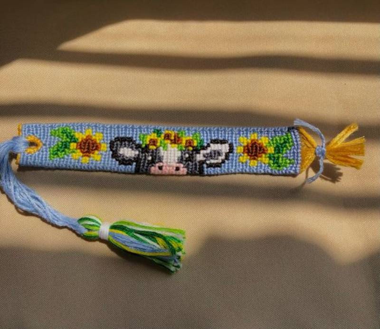 Pulsera de hilo de vaquita con girasoles.