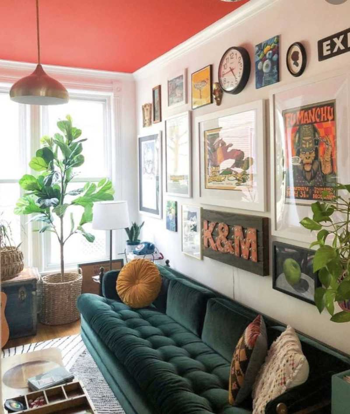 Salón retro-glam con sofá verde esmeralda y posters.