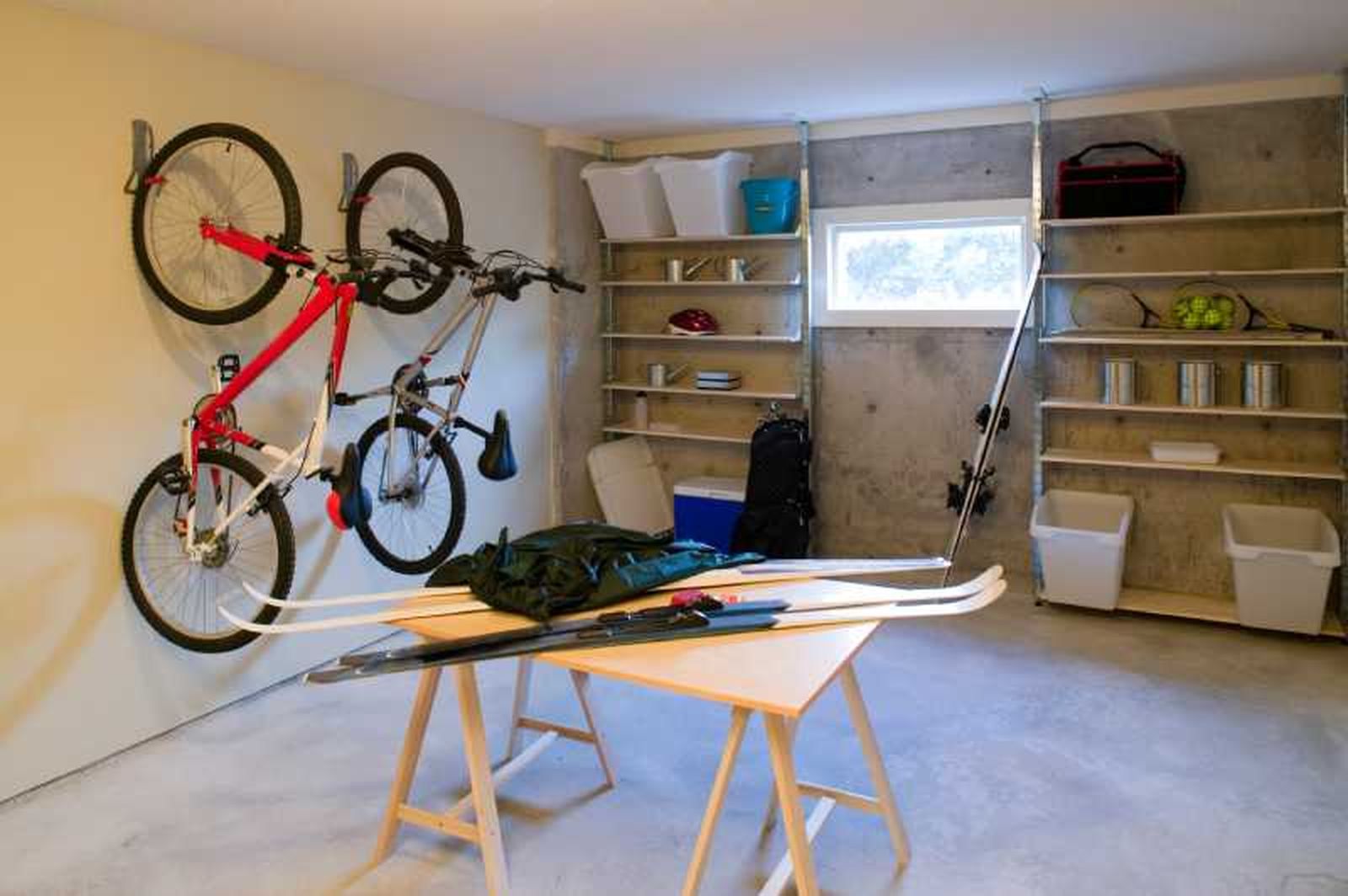 Garaje con bicis en la pared bien organizado.
