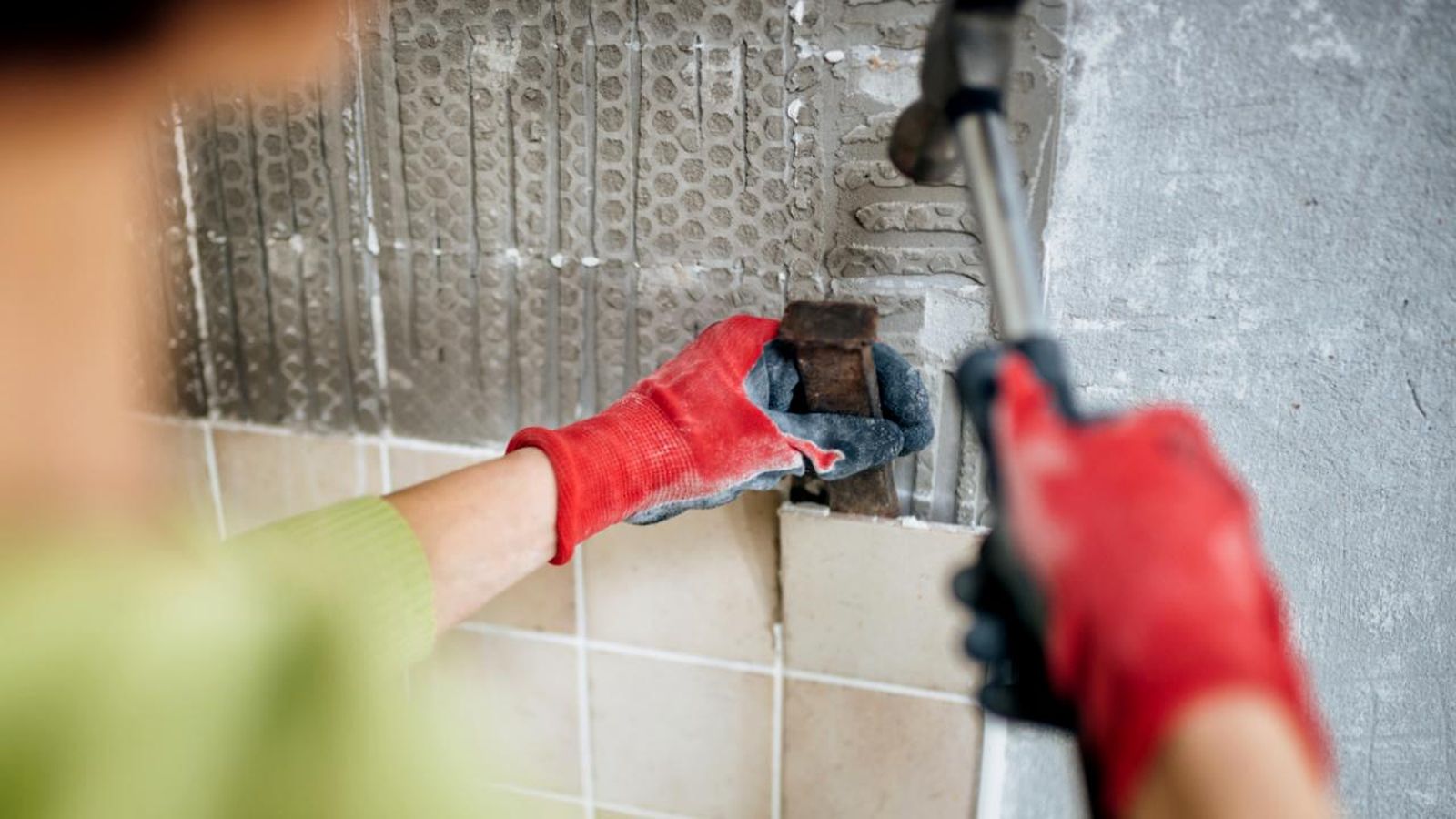 Persona quitando los azulejos de la pared