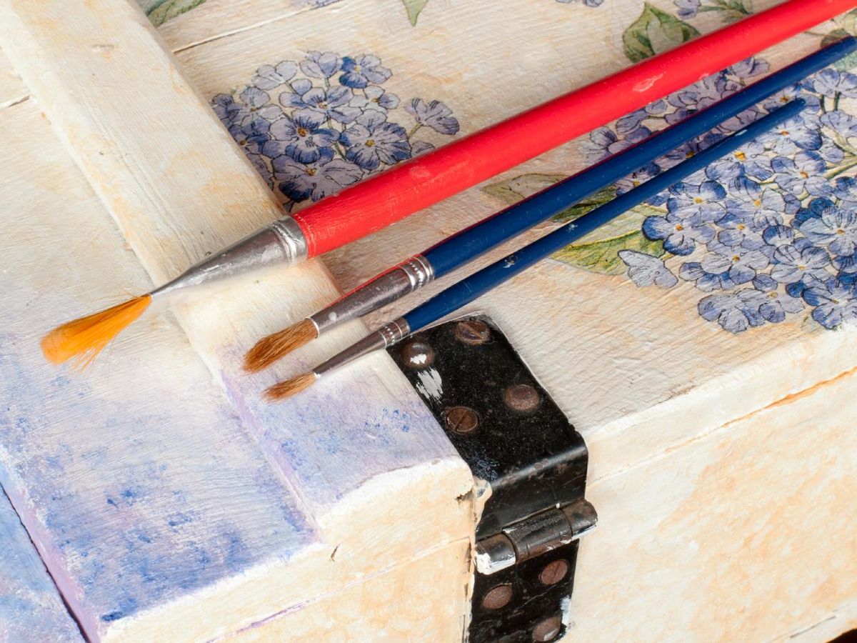 Bandeja de madera con decoupage floral y pinceles.
