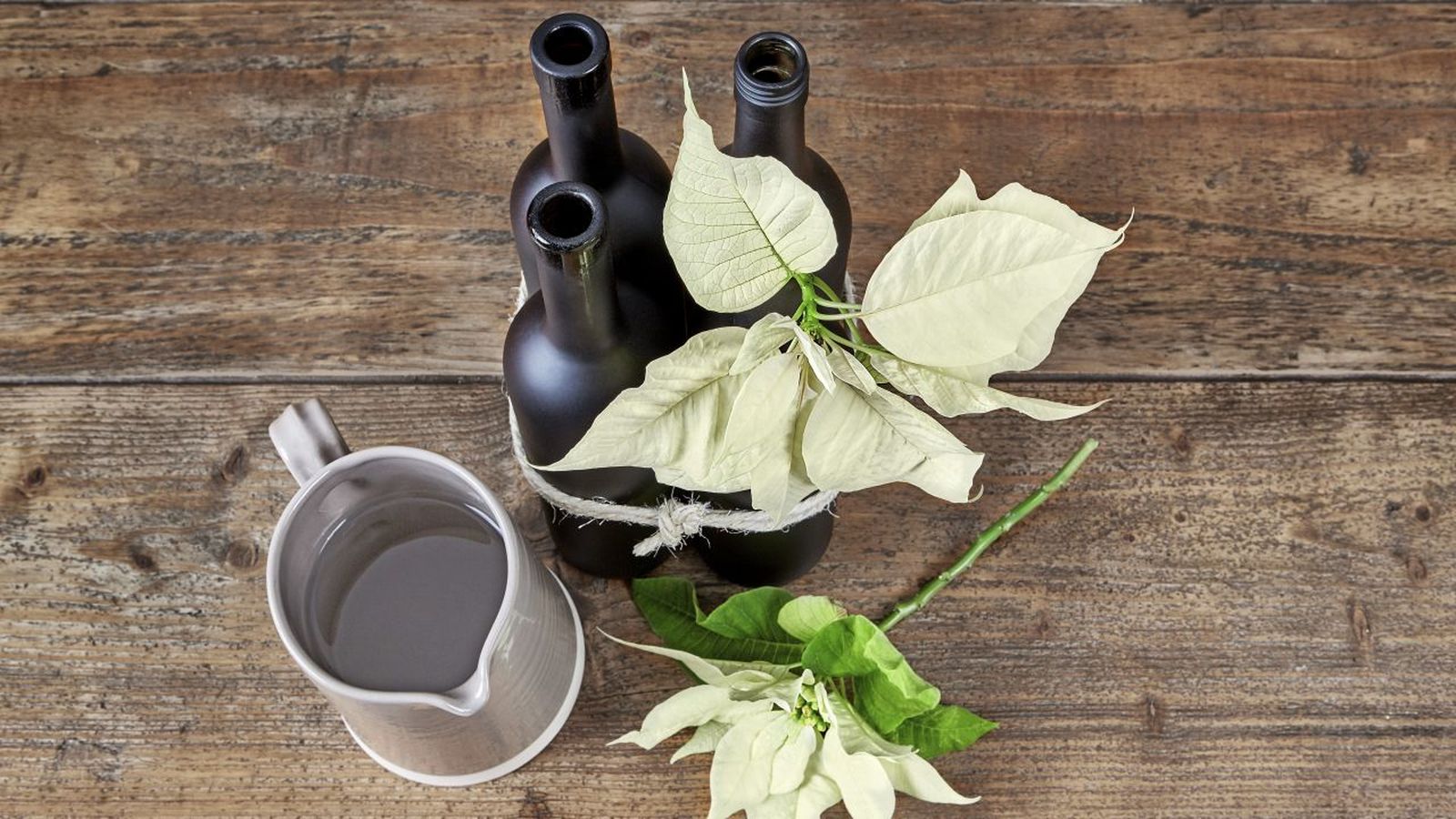 Centro de mesa con flor de Pascua en botellas
