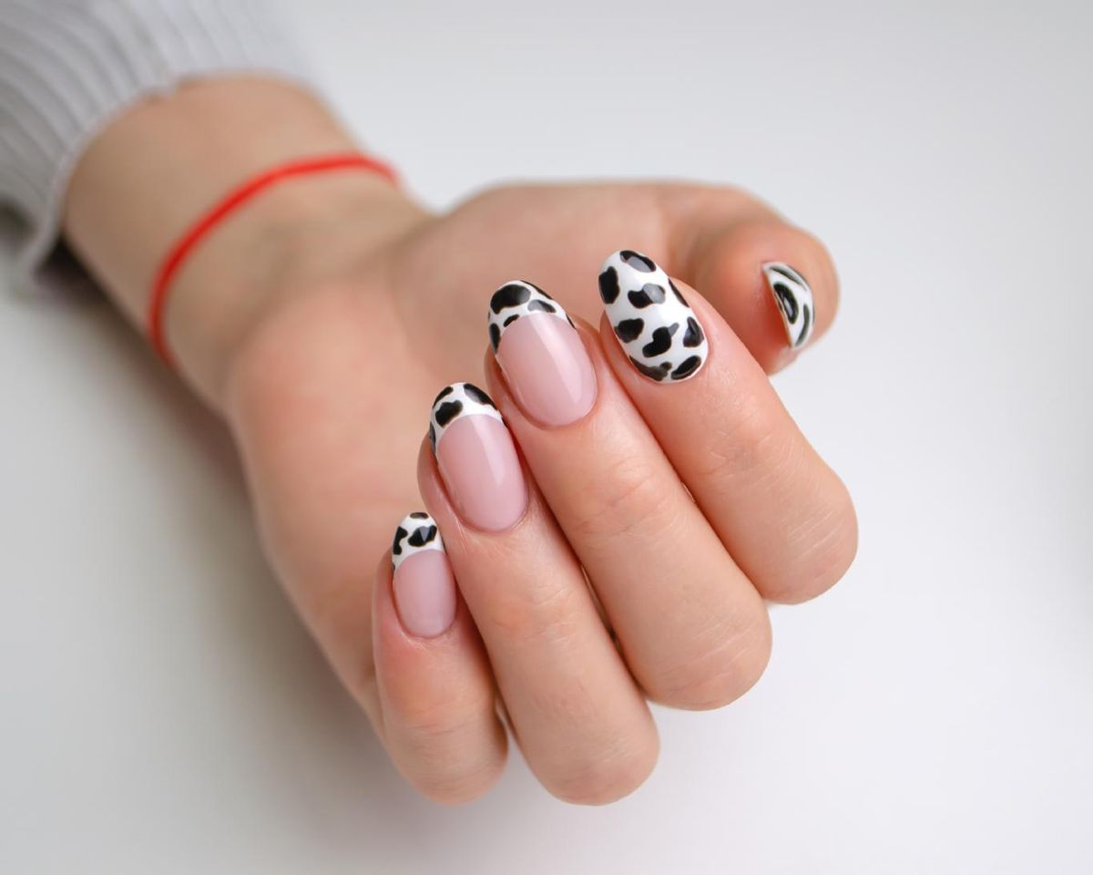 Uñas francesas con diseño de vaca.