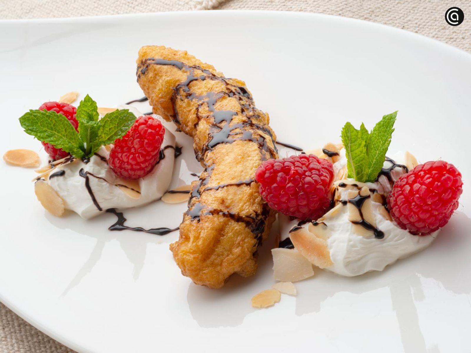 Un postre fácil con sirope de chocolate, nata montada y almendras