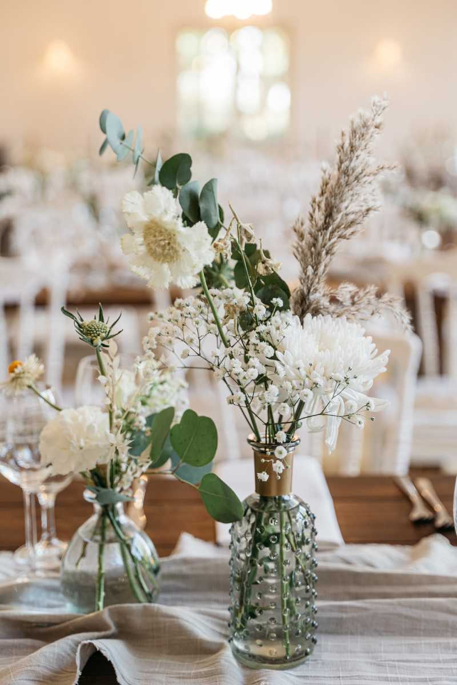 Centro de mesa para boda en botella de vidrio.