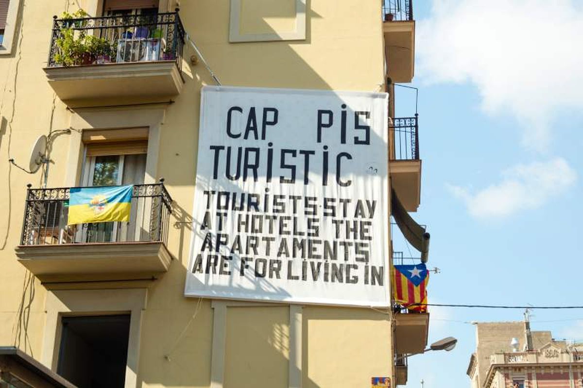 Cartel que se queja sobre la masificación de los pisos turísticos en Barcelona