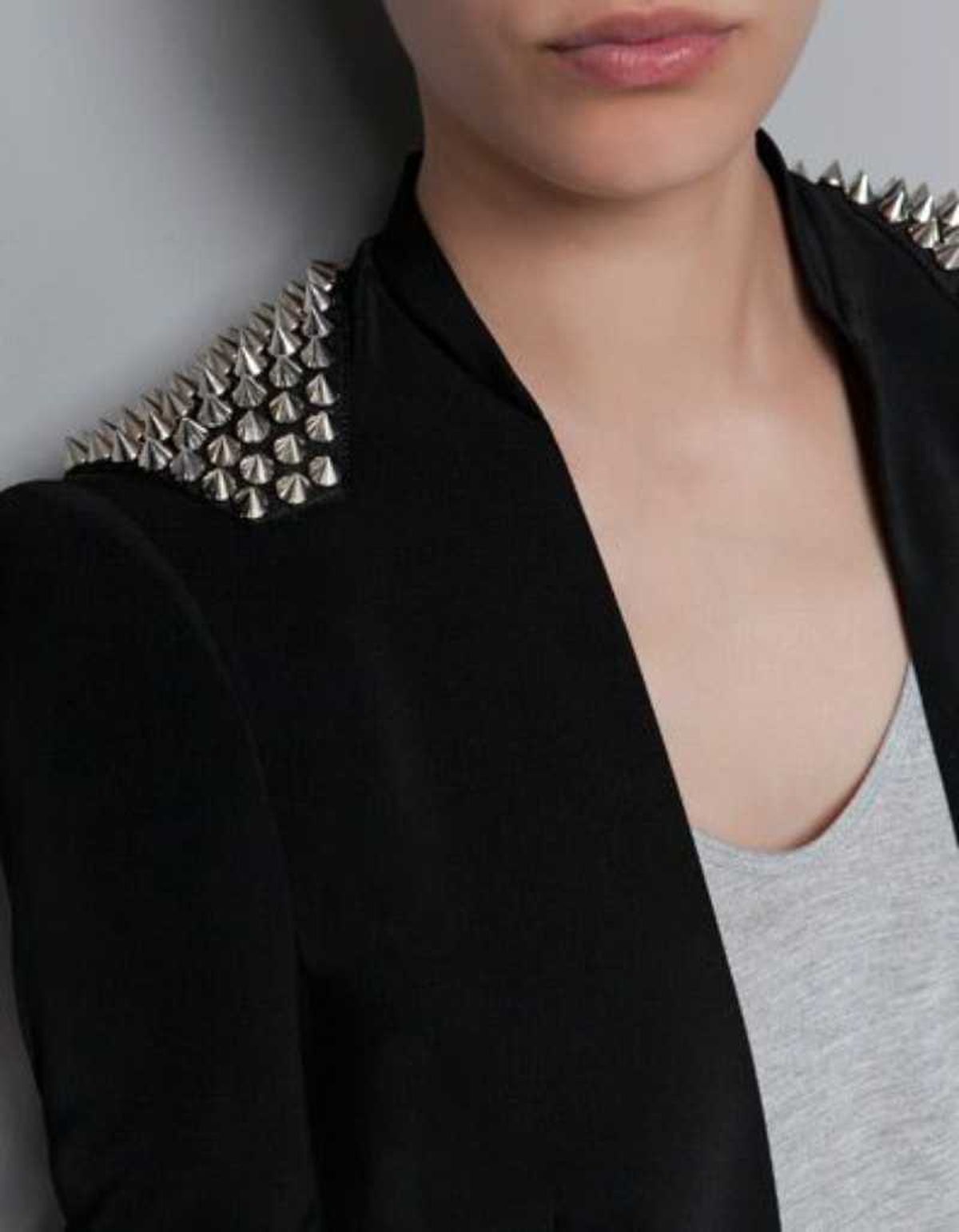 Mujer con blazer negra con hombreras de pinchos.