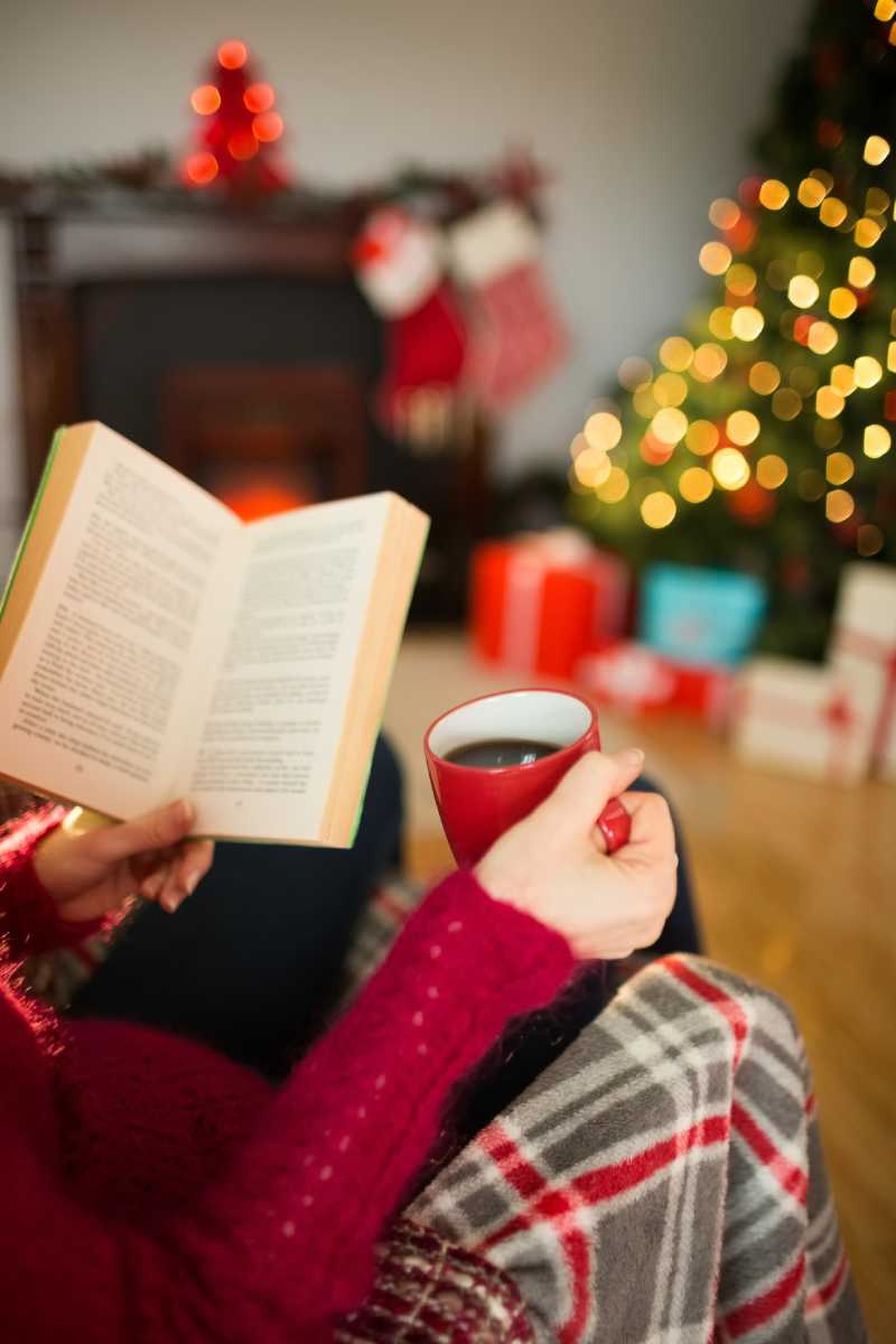 Mujer leyendo un salón con decoración Navidad.