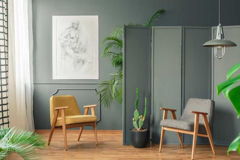 Rincón de un salón con biombo verde mate.