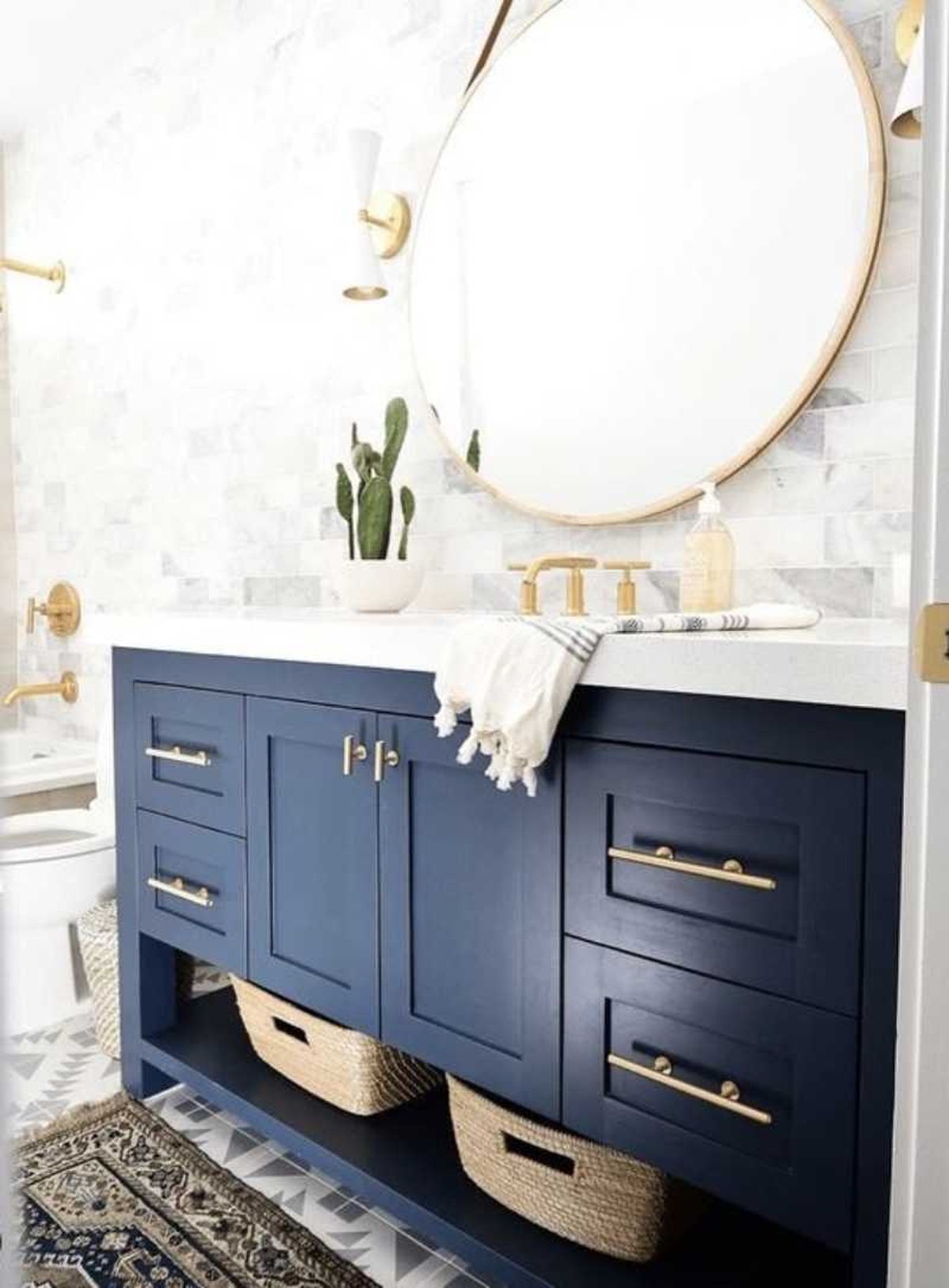 Baño con mueble azul y detalles dorados.