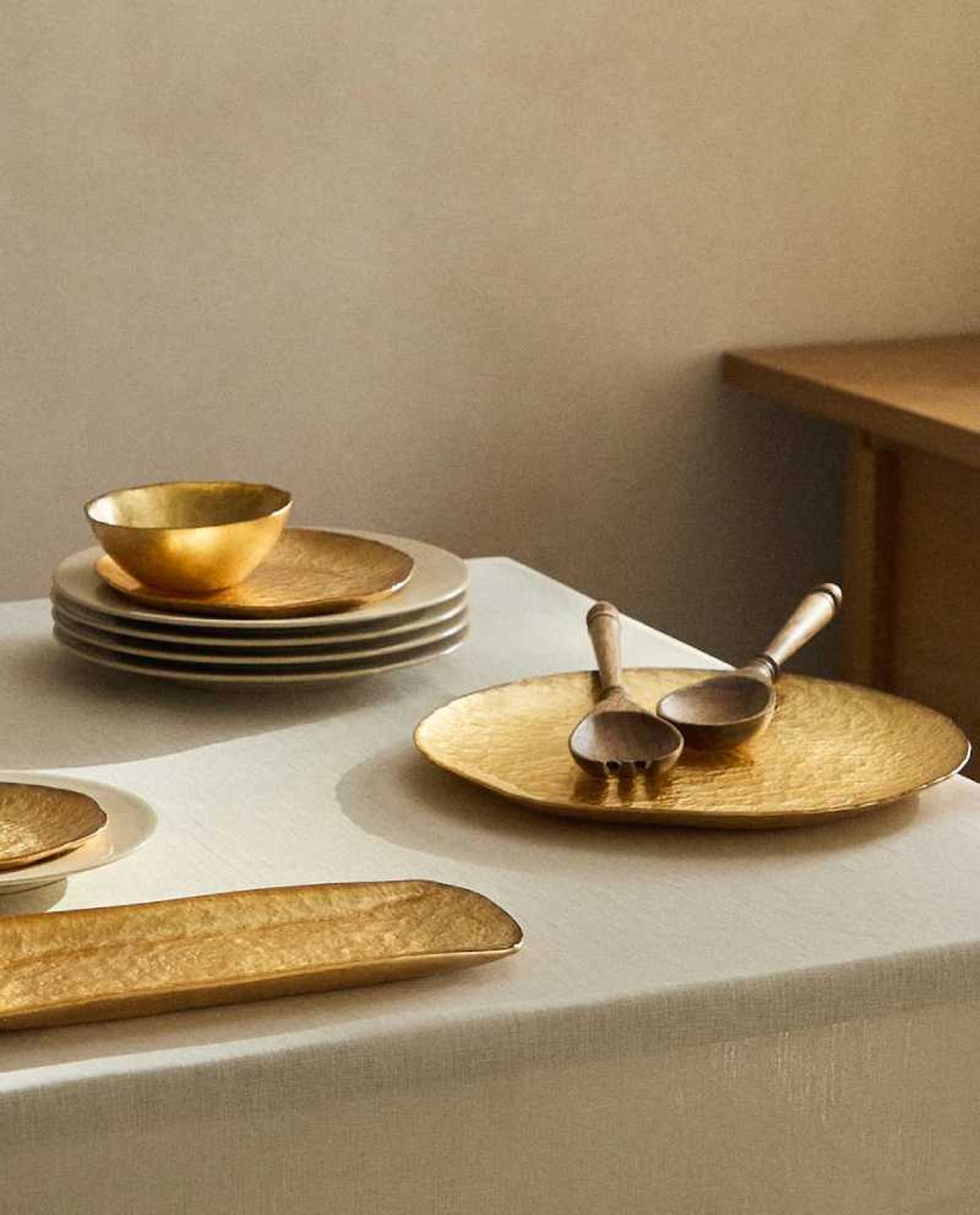 Mesa con vajilla dorada de estilo tradicional.