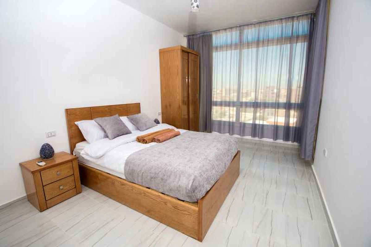 Dormitorio pequeño en gris, madera y tonos claros.