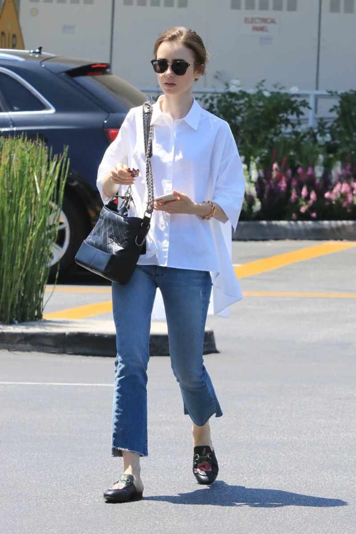 Lily Collins con vaquero cropped y camisa blanca
